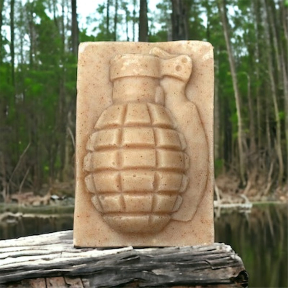 Fu*k Bugs citronella grenade soap bar on a log by a forest pond