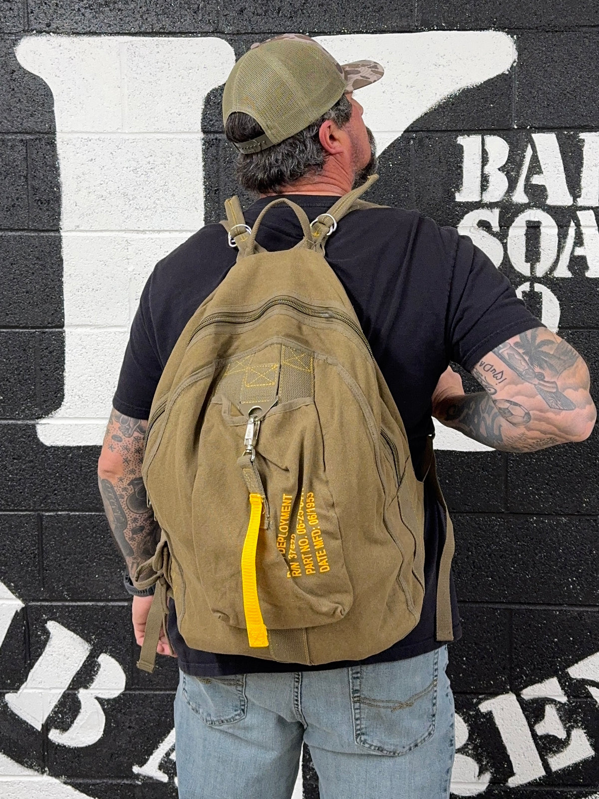 Man wearing the Tim Kennedy Bag of Frag backpack in front of the K Bar logo