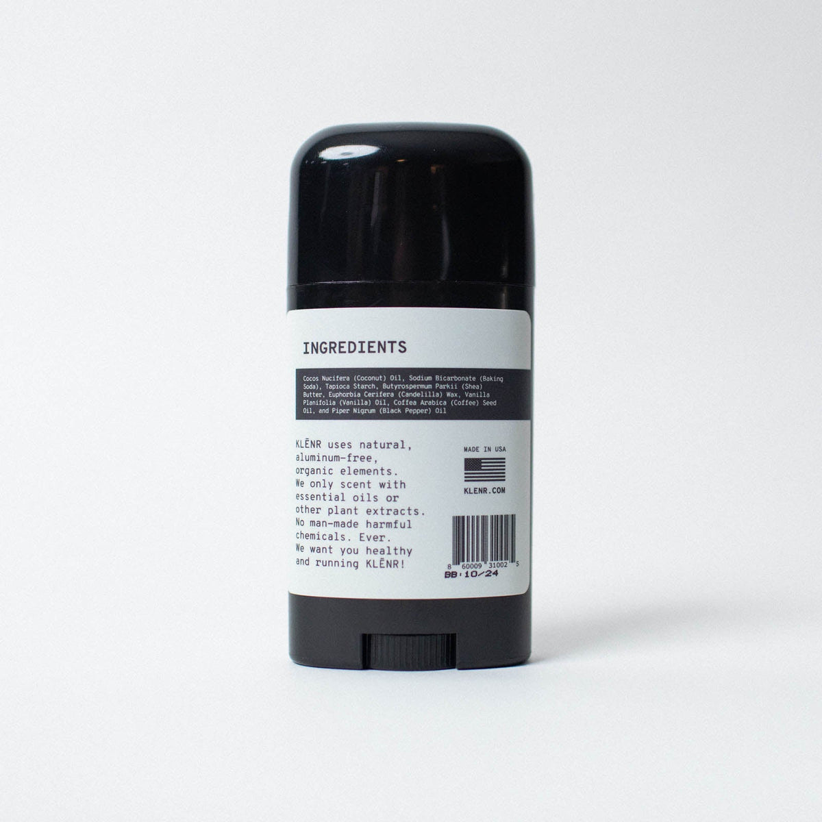 Black deodorant stick with a white label on a light gray background