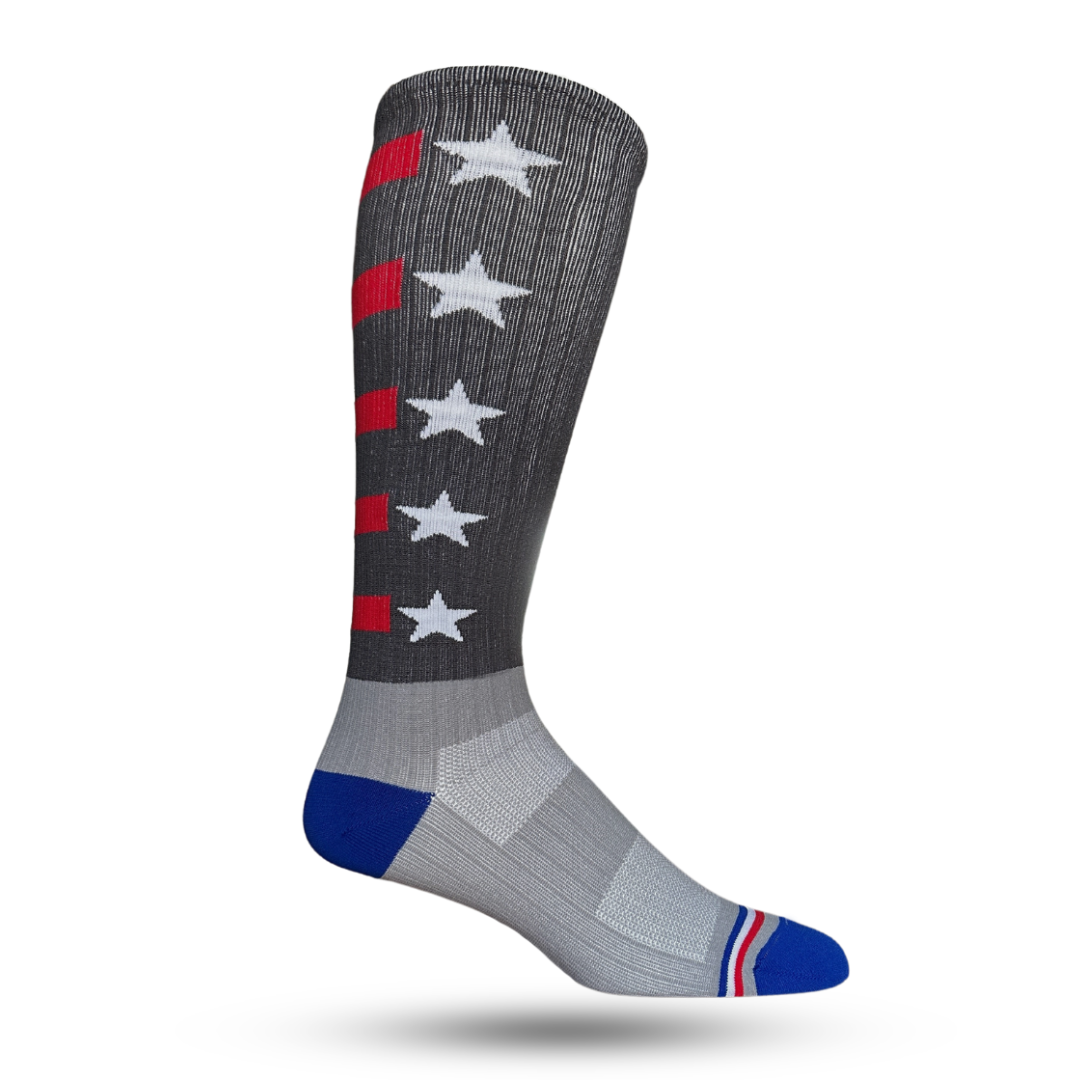 A pair of lightweight compression crew socks featuring a stars and stripes pattern in shades of gray, blue, and red, with a visible logo on the ankle.