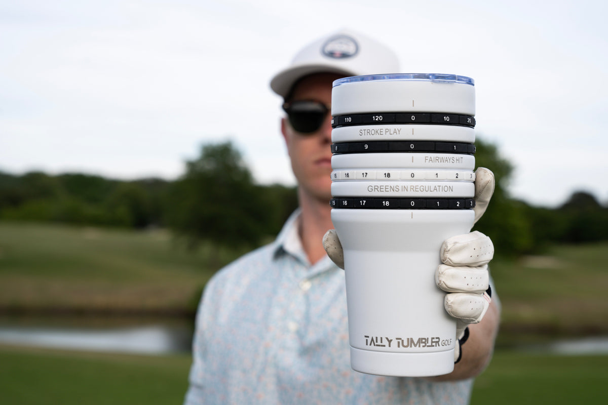 Person holding a Tally Tumbler with a golf course in the background