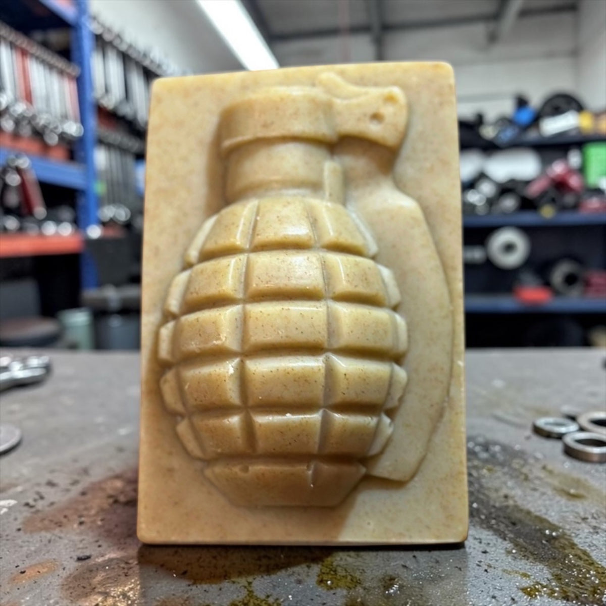 Grease Gun mechanic's grenade soap bar on a shop workbench