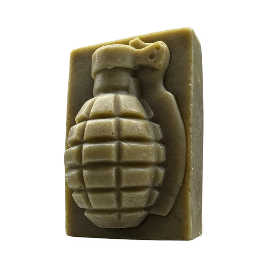 A bar of soap with a grenade shape imprinted on it, colored in a greenish hue, likely representing the product 'All New BUSHWACKER Grenade Soap'.