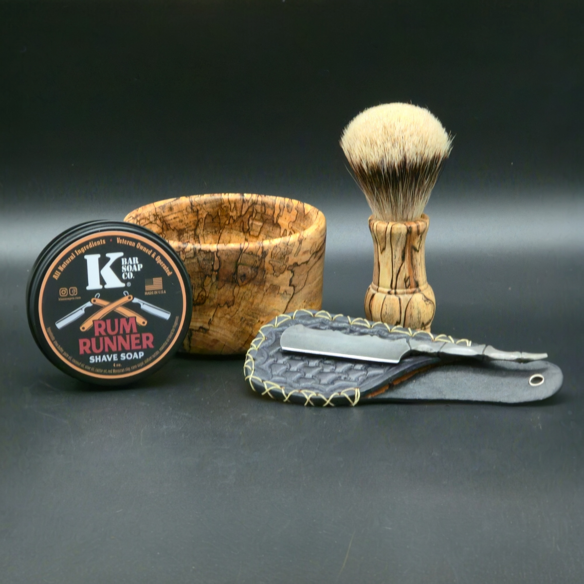 Shaving set with brush, soap, and razors on a dark background