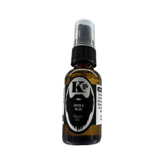 A clear glass bottle with a spray nozzle, labeled 'K. Opal Mae' with a black label and white text, indicating the product is a premium beard oil.