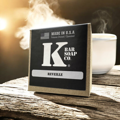 Reveille coffee bar soap box next to a steaming cup of coffee