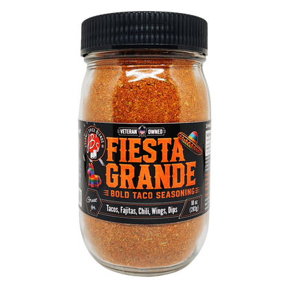 A glass jar of Fiesta Grande Bold Taco Seasoning with a black ribbed lid and a black label featuring orange and white text, set against a plain white background.