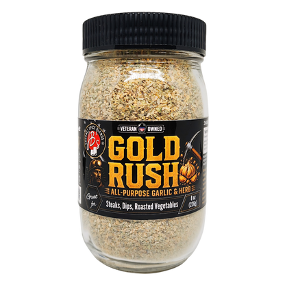 A jar of Gold Rush All-Purpose Garlic & Herb seasoning blend by Big Bill's BBQ, featuring a black lid and a black label with yellow and white text, set against a plain white background.