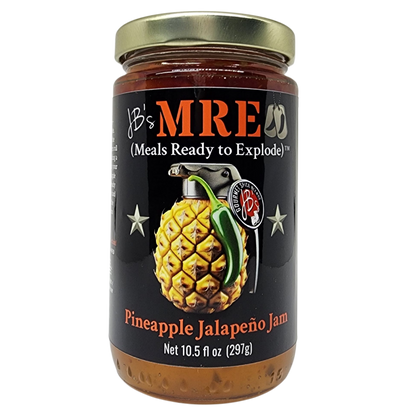 A jar of JB's MRE Pineapple Jalapeño Jam with a black label, gold lid, and graphic of a grenade shaped like a pineapple on a white background.