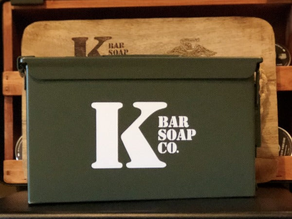 .50 Cal Ammo Can with K Bar Logo and Wood Cutting Board behind it