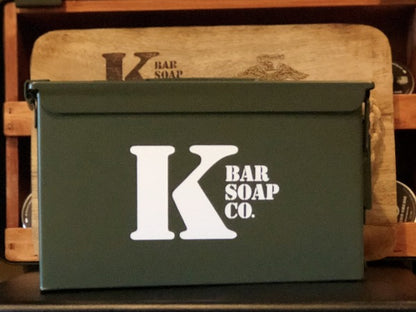 .50 Cal Ammo Can with K Bar Logo and Wood Cutting Board behind it