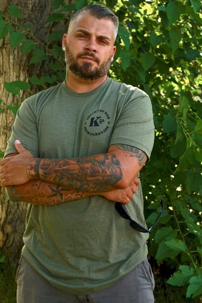 Man with OD Green Triblend K Bar logo shirt with arms folded