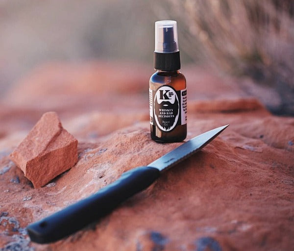 
                  
                    Whiskey & Bad Decisions Beard Oil on rock with knife
                  
                